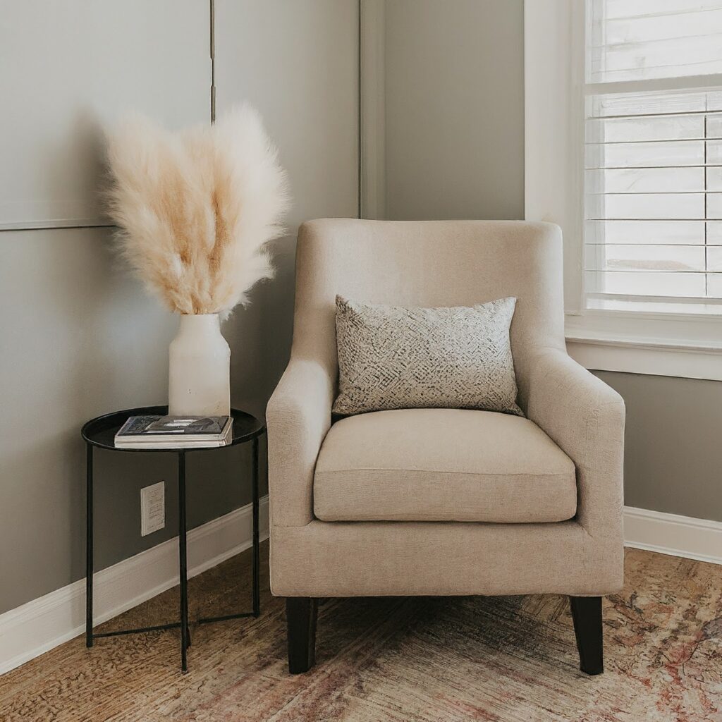 Cozy reading nook with a small table holding a vase of pampas grass.