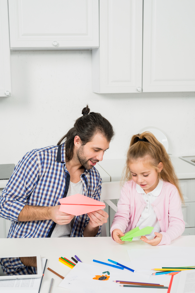 a parent and child working on a scrapbook together.